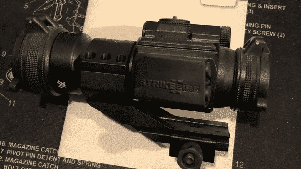 Black Vortex Strikefire Red Dot on cantilever mount sitting on product manual.